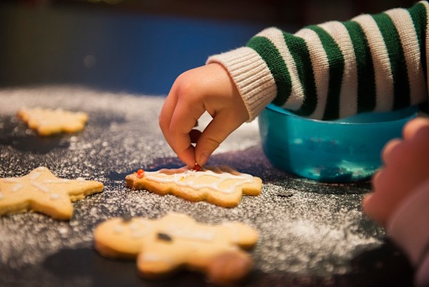 A child decorated Christmas biscuits.