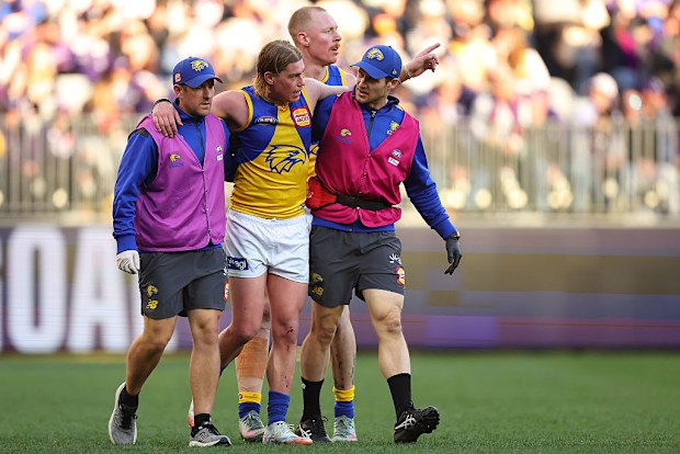 Harley Reid of the Eagles is assisted from the field.
