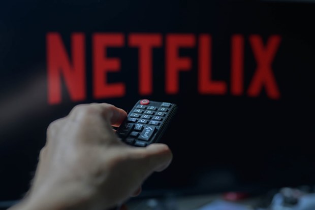 A person is holding a TV remote with Netflix visible in the background in this photo illustration taken in Brussels, Belgium, on May 5, 2024. (Photo by Jonathan Raa/NurPhoto)