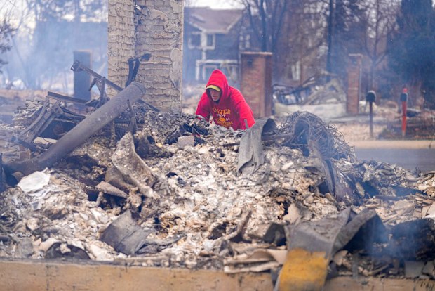Todd Lovrien looks over the fire damage from the Marshall Wildfire at his sisters home in Louisville.