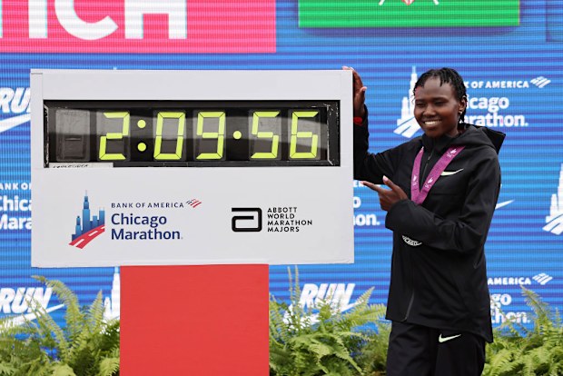 Ruth Chepngetich of Kenya poses with a clock after winning the 2024 Chicago Marathon.