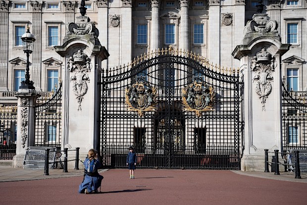 A young boys poses for a photo outside Buckingham Palace on April 26, 2020.