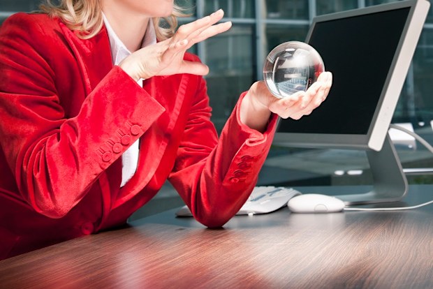 Woman looking into crystal ball in office