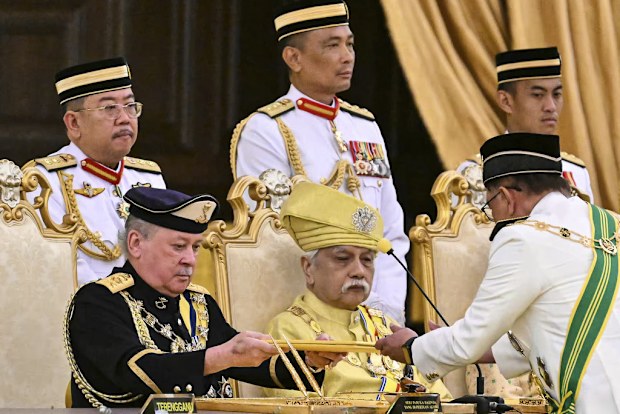 Sultan of Johor, Sultan Ibrahim Iskandar, left, receives documents from Malaysia's Prime Minister Anwar Ibrahim during the oath taking ceremony as the 17th King of Malaysia at the National Palace in Kuala Lumpur on Wednesday, Jan. 31, 2024.  