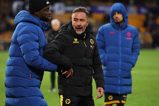 Vitor Pereira is held after clashing with supporters after their defeat.