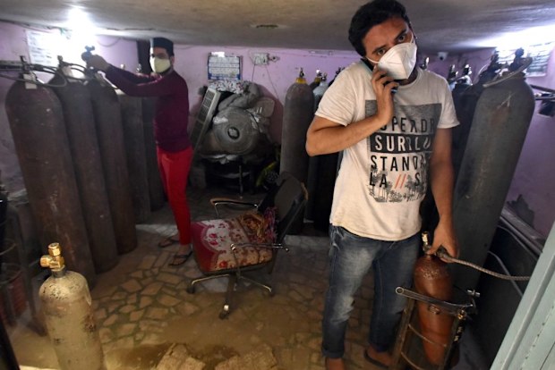People fill up oxygen cylinders for housed patients at Shaheen Bagh   in New Delhi.