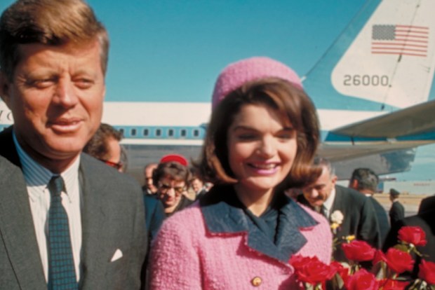 President John F. Kennedy and his wife Jackie, who is holding a bouquet of roses, just after their arrival at the airport for the fateful drive through Dallas.