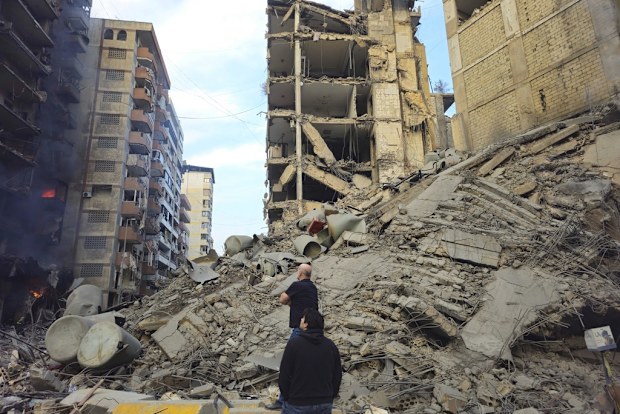 Residents check the site of an Israeli airstrike in Dahiyeh, Beirut