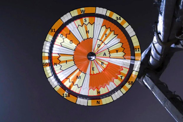 This illustration provided by NASA shows a diagram added over the parachute deployed during the descent of the Mars Perseverance rover as it approaches the surface of the planet on Thursday, Feb. 18, 2021. Systems engineer Ian Clark used a binary code to spell out Dare Mighty Things in the orange and white strips of the 70-foot (21-meter) parachute. He also included the GPS coordinates for the mission's headquarters at the Jet Propulsion Laboratory in Pasadena, Calif. (NASA/JPL-Caltech via AP)