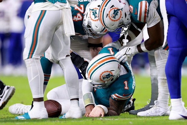Tua Tagovailoa of the Miami Dolphins lays on the ground.