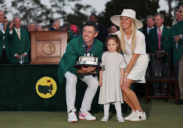 Rory McIlroy of Northern Ireland poses with daughter Poppy and wife Erica Stoll holding the Masters trophy during the Green Jacket Ceremony, 2025
