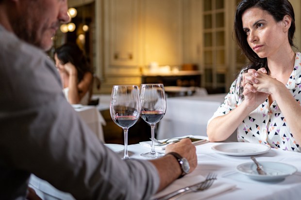 Adult couple arguing at a restaurant during a dinner.