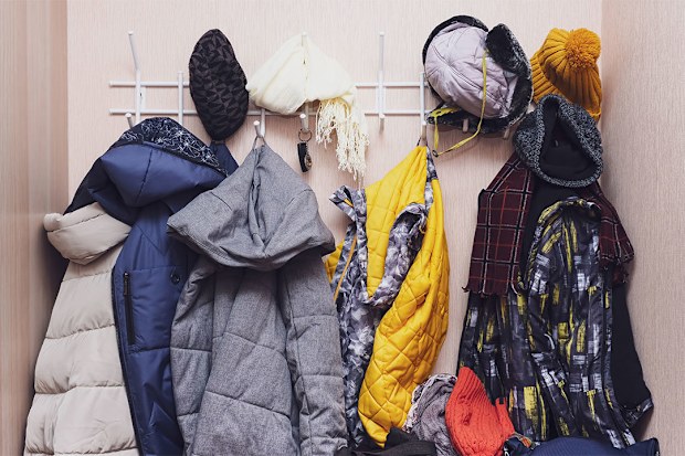 Winter gear, coats, jackets, scarves, beanies on entryway hooks