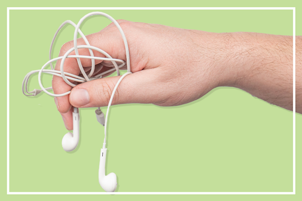 9PR: Apple EarPods tangled held in man's hand on green background