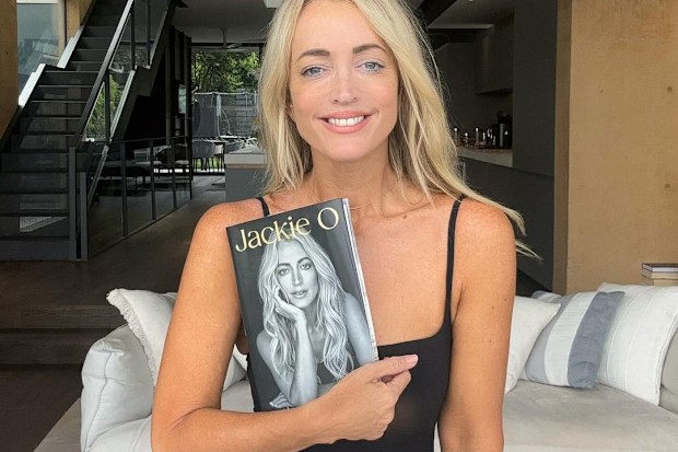 Jackie O Henderson holding her memoir