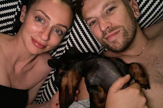 Dylan Alcott in bed with his girlfriend, Chantelle Otten, and their dog Sauce.
