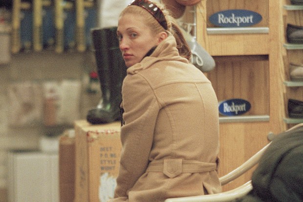 Carolyn Bessette seated in a shoe store in New York, 1996