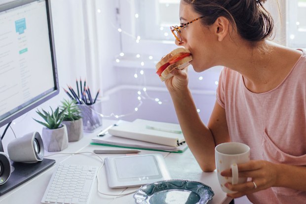 Woman eating while working from home.