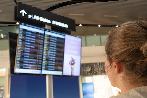 A young woman looking at the flight details board at the airport