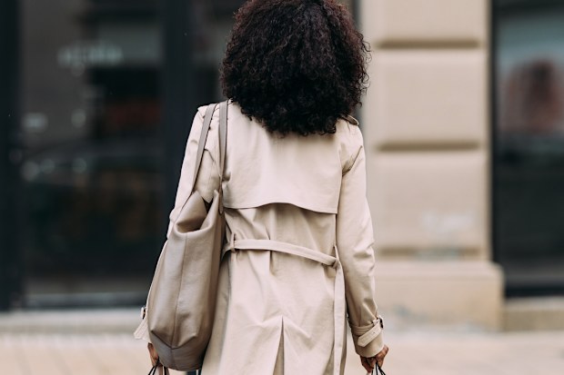City chic haul: A woman carries her shopping bags, showcasing her fashionable finds.