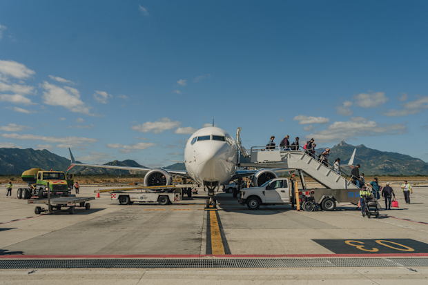 People disembarking a plane on the tarmac