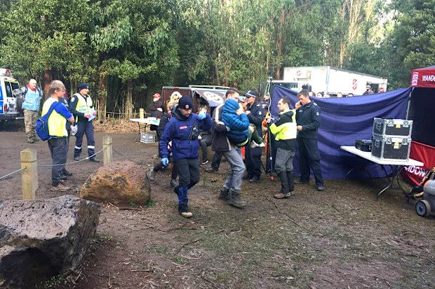 William Callaghan survived two nights of bitterly cold temperatures, wearing just blue tracksuit pants and a hoodie. Here he is seen in a blue jacket, being carried as search party members look on