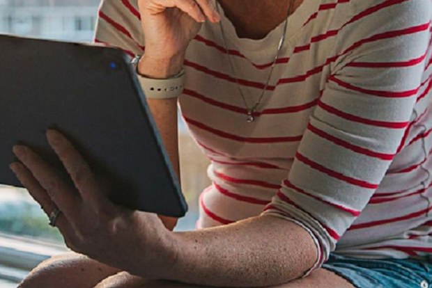 Woman sitting at home on computer sad