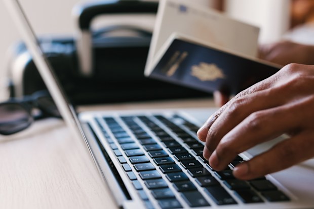 Passport and man on laptop booking vacation, vacation or flight to tropical destination and reading hotel website, concept of Travelling.