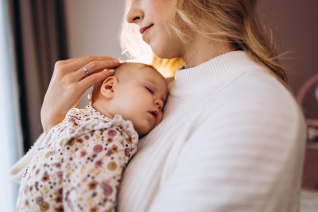 Mum holding sleeping baby girl