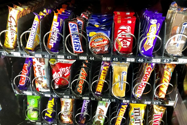 Chocolate bars, cakes and biscuits in a snack vending machine.