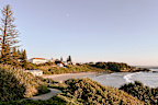 Horizontal landscape view of a path leading to the sand beach with waves rolling in and coastal forest on the headland at Yamba Beach, popular tourist destination, Yamba, NSW.