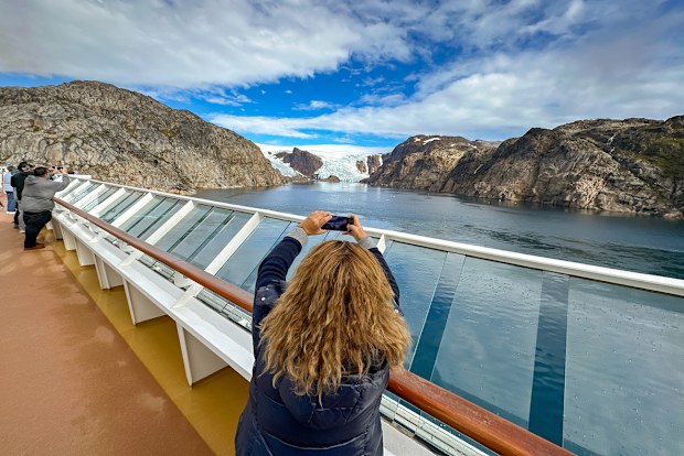 Prince Christian Sound, Greenland - 29 August 2024: Cruise ship passengers looking at the granite rock face on the side of a fjord in Prince Kristian Sund