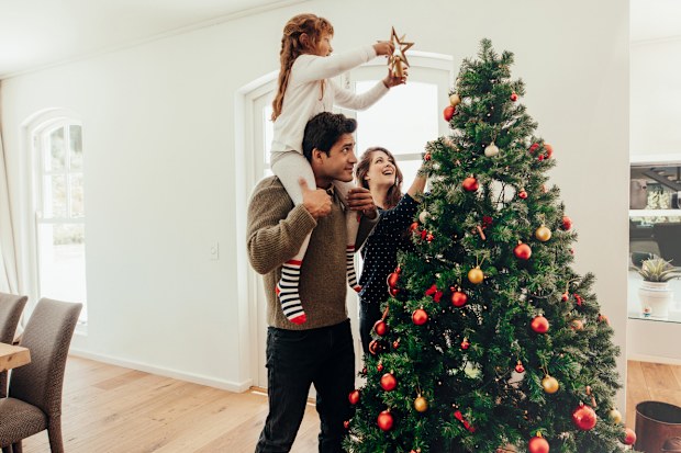 Family decorating a Christmas tree. 