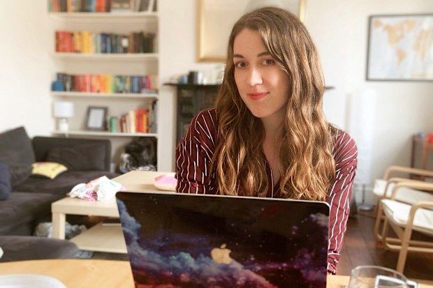 Author Samantha Shannon writing at her laptop.