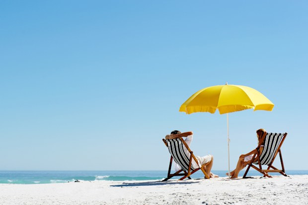 beach umbrella. couple at the beach. people at the beach.