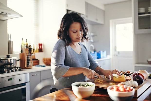 Woman cooking at home in front of stove.