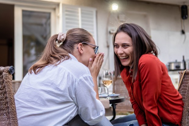 Woman whispering in friend's ear 