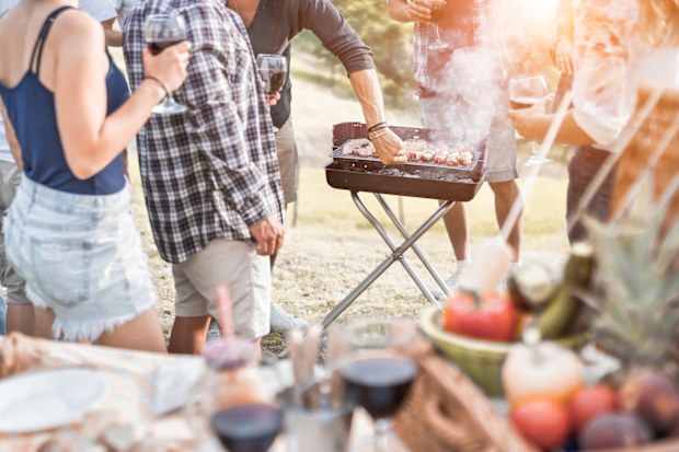 Happy friends gathered at the BBQ on a summer getaway.