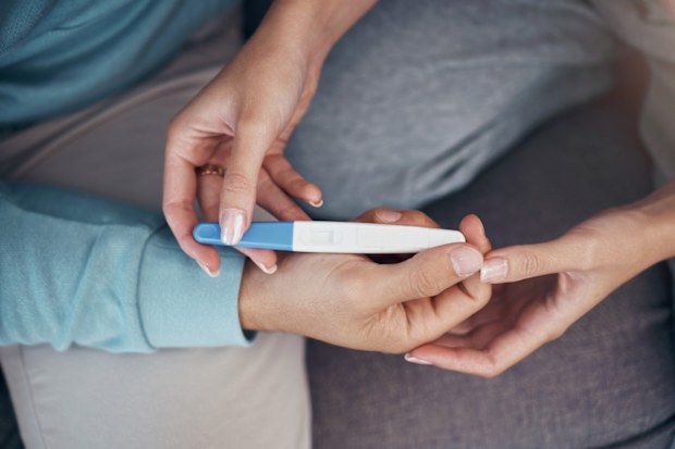Man and woman's hands holding pregnancy test