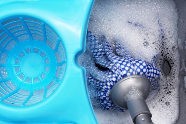 A modern mop and plastic bucket with water and suds.