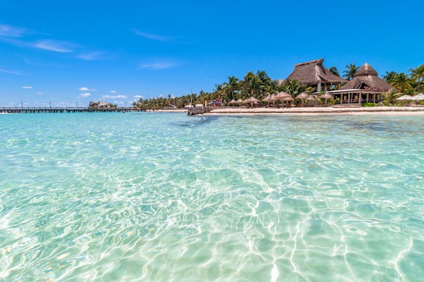 Isla Mujeres, Mexico - April 22, 2014:  day view of tropical sea and coastline on famous Playa del Norte beach in Isla Mujeres, Mexico. The island is located 8 miles northeast of Cancún in the Caribbean Sea
