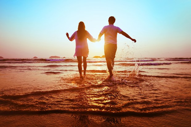 Couple enjoy beach sunset.