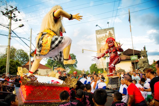 Battle of the Ogoh-Ogohs during Nyepi Ngrupuk parade in Lovina, North Bali, Indonesia. The two handmade ogress statues, reprensenting all evil things in men are rushed forward by two groups of men and children, simulating a fight at the town square.