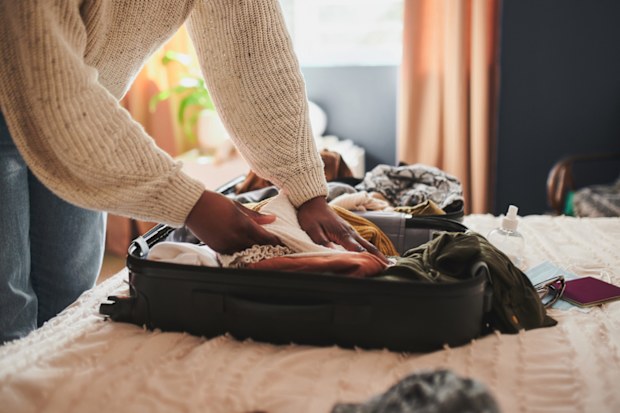 I can't leave this behind woman packing suitcase