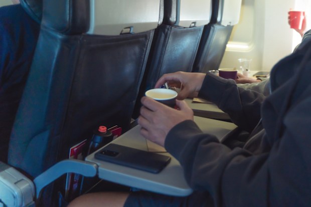 A person is drinking coffee in an airplane