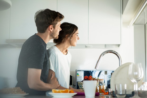 Couple smiling and looking outside the house