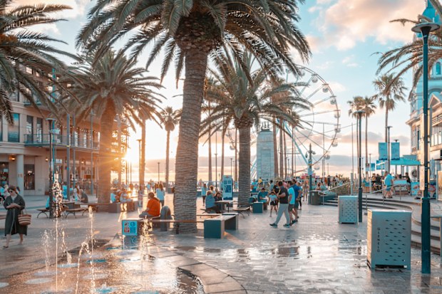 Adelaide, Australia - January 2, 2013: Iconic Moseley Square in Glenelg with people at sunset time. Pioneer Memorial and Giant Ferris Wheel can be seen in the background.