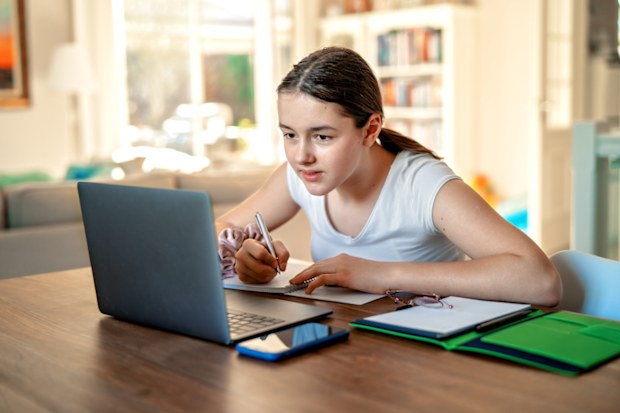 Teenager studying. Teenager doing homework. Teenage girl studying at home.