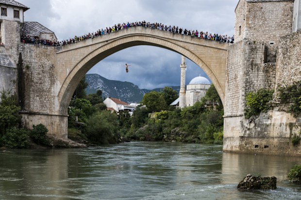 A crowd watches as a man leaps off the Stari Most above the Neretva River in Mostar, Bosnia and Herzegovina.