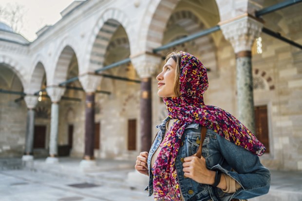 Young veiled woman in the courtyard of the Suleymaniye Mosque in Istanbul, Turkey